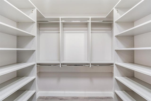 walk in closet with wood finished floors