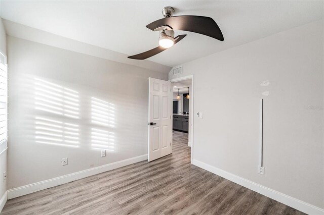 spare room with ceiling fan, baseboards, visible vents, and light wood-style floors