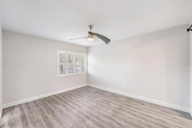 empty room featuring ceiling fan, baseboards, and light wood-style flooring