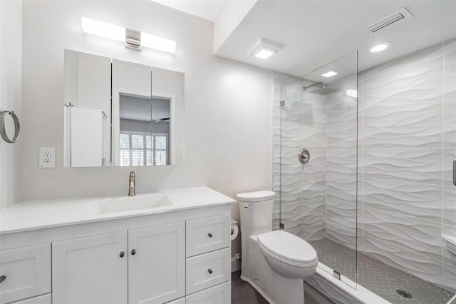 full bathroom featuring a stall shower, visible vents, vanity, and toilet