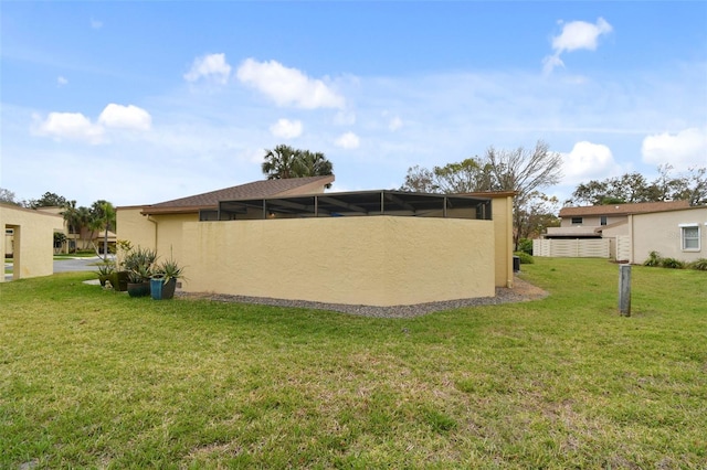 back of house with a yard and stucco siding