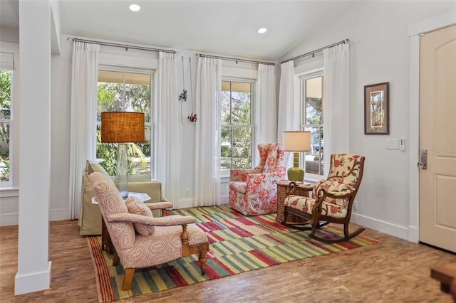 living area featuring hardwood / wood-style flooring, lofted ceiling, and plenty of natural light