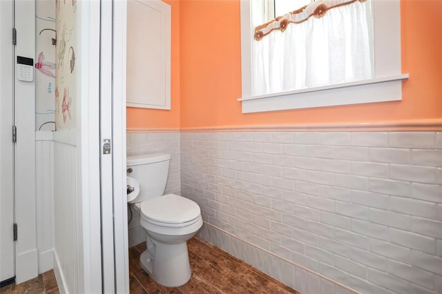 bathroom featuring hardwood / wood-style floors, tile walls, and toilet