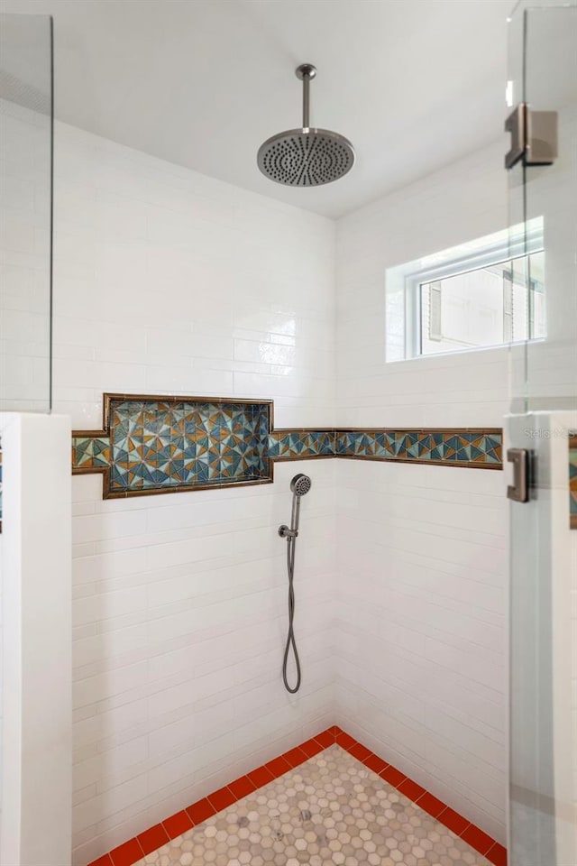 bathroom with tile patterned flooring and a tile shower