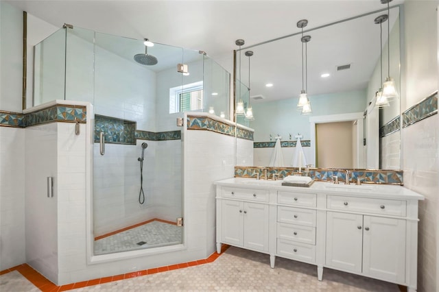 full bathroom featuring double vanity, a shower stall, visible vents, and a sink