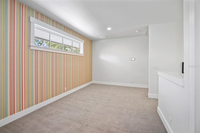 spare room featuring light carpet, wallpapered walls, baseboards, and recessed lighting