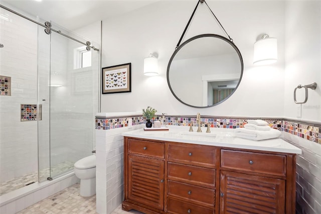 bathroom with vanity, toilet, an enclosed shower, and tile walls