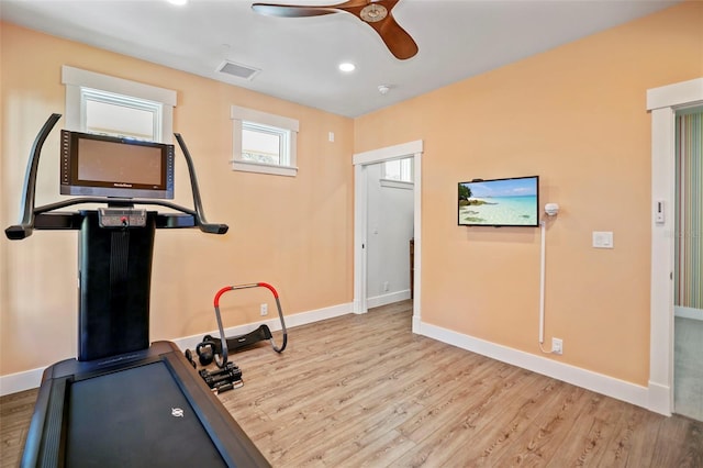 exercise room with ceiling fan and light hardwood / wood-style floors