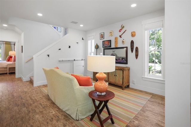 living room featuring visible vents, stairway, light wood-style flooring, and recessed lighting