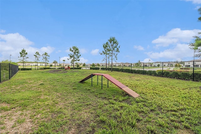 view of property's community with a yard and fence