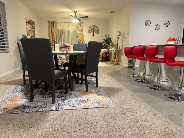 dining room featuring baseboards, visible vents, ceiling fan, and a dry bar