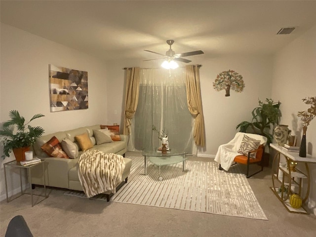 sitting room with carpet, visible vents, and a ceiling fan