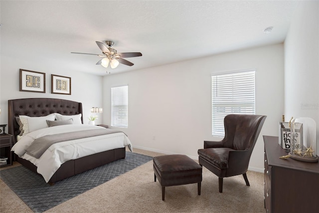 carpeted bedroom with ceiling fan and baseboards