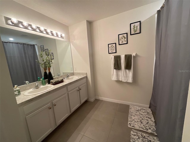 full bathroom featuring tile patterned flooring, a sink, baseboards, and double vanity