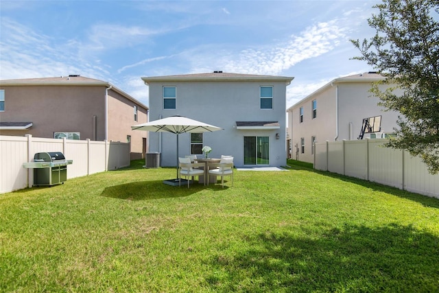 back of house with a yard, central AC, fence private yard, and stucco siding