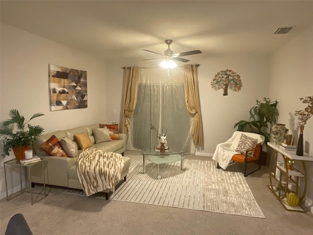 living room featuring carpet floors, baseboards, ceiling fan, and visible vents
