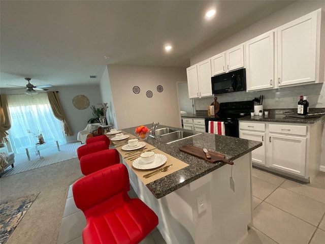 kitchen featuring a sink, tasteful backsplash, black appliances, and white cabinetry