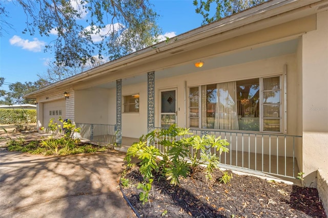 property entrance featuring a garage and covered porch