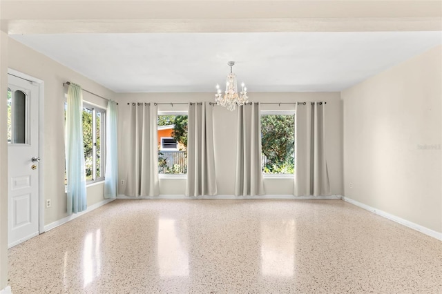 spare room with an inviting chandelier