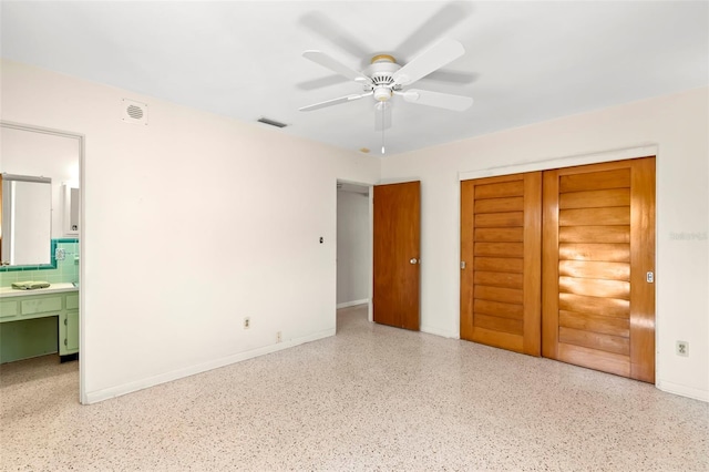 unfurnished bedroom featuring ensuite bathroom, ceiling fan, and a closet