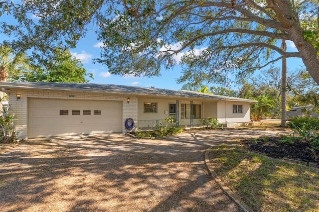 ranch-style home featuring a garage and covered porch