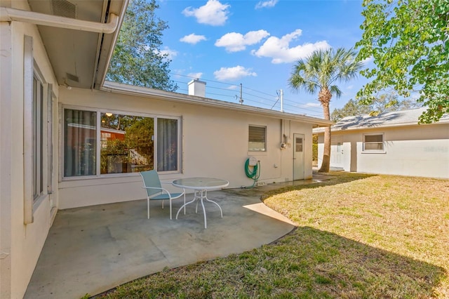 back of house with a yard and a patio