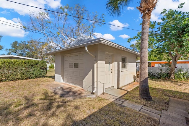 view of outdoor structure with a garage and a lawn