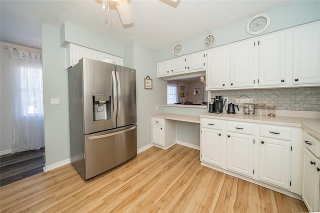 kitchen featuring decorative backsplash, stainless steel fridge, light hardwood / wood-style floors, and white cabinets