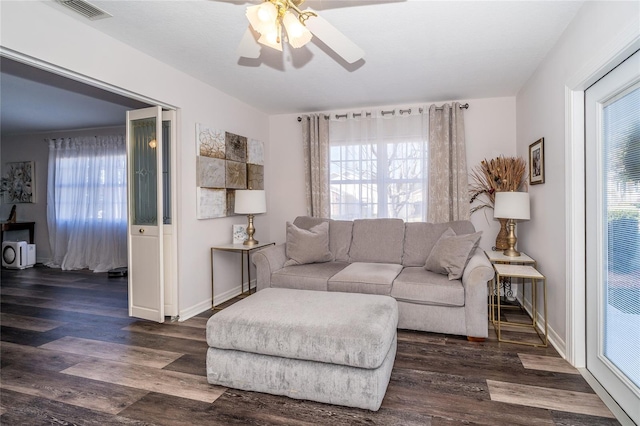 living room featuring dark wood-type flooring and ceiling fan