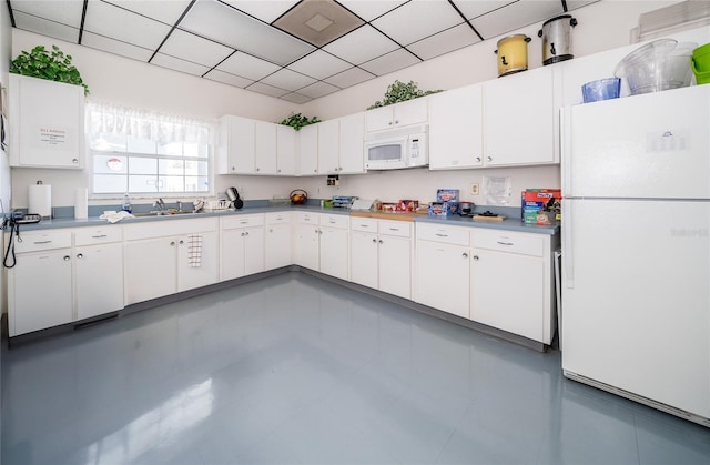 kitchen featuring sink, white cabinets, and white appliances