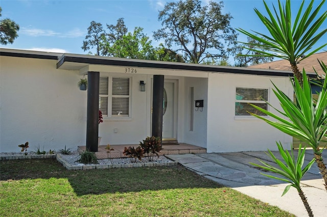 doorway to property with a yard