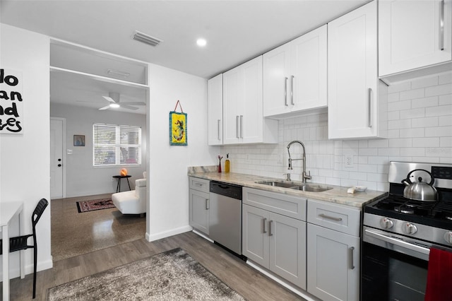 kitchen with dark hardwood / wood-style flooring, sink, stainless steel appliances, and white cabinets