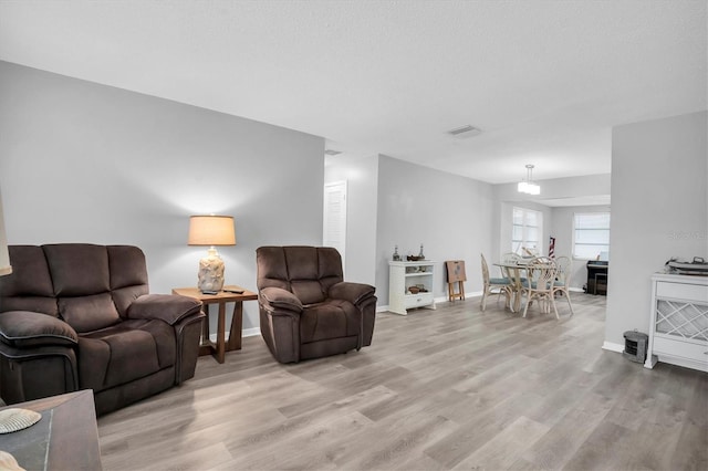 living room featuring a textured ceiling and light wood-type flooring