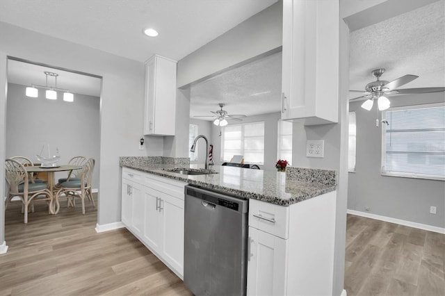 kitchen featuring white cabinetry, dishwasher, sink, dark stone countertops, and a textured ceiling