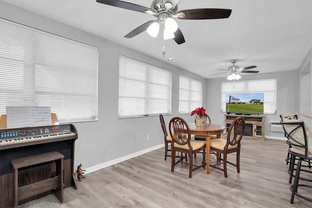 dining area with a textured ceiling and light wood-type flooring