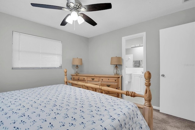 bedroom featuring ceiling fan, light colored carpet, and connected bathroom