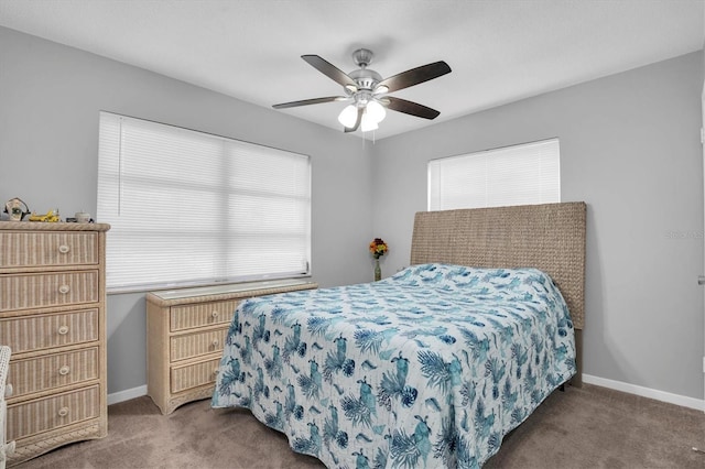 bedroom with multiple windows, ceiling fan, and dark colored carpet