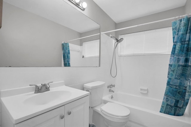 full bathroom with shower / bathtub combination with curtain, vanity, toilet, and tile walls