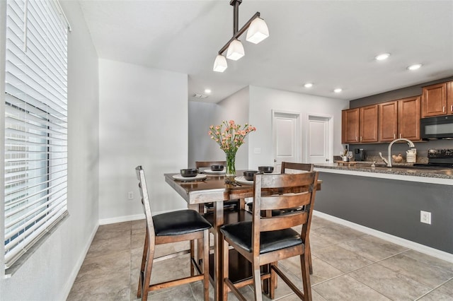 dining area featuring light tile patterned flooring and sink