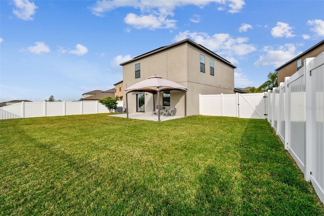 back of house featuring a yard, a gazebo, and a patio area