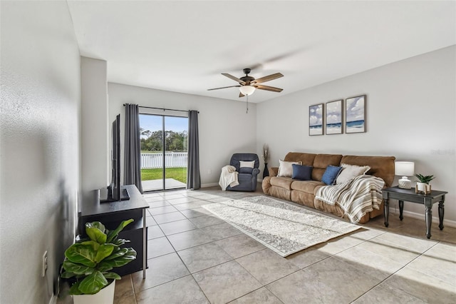 living area with ceiling fan, baseboards, and light tile patterned floors