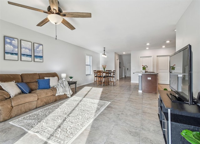 living area featuring light tile patterned flooring, ceiling fan, baseboards, and recessed lighting