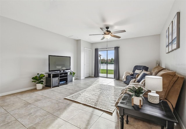 living area with ceiling fan, baseboards, and light tile patterned flooring