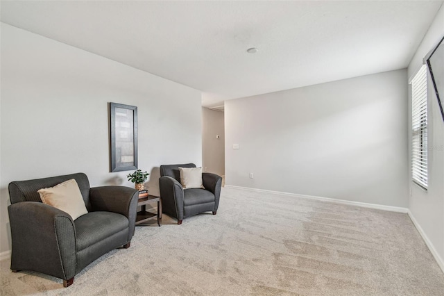 living area with light carpet and baseboards