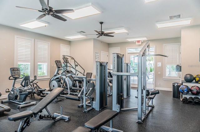 gym with a ceiling fan, visible vents, and baseboards