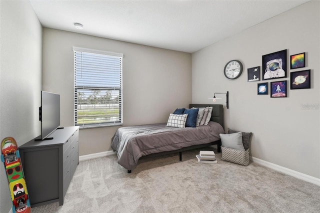 bedroom featuring baseboards and light colored carpet