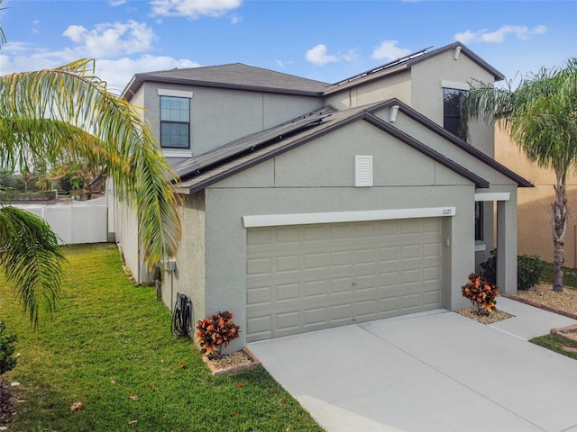 view of front facade with concrete driveway, a front lawn, fence, and stucco siding