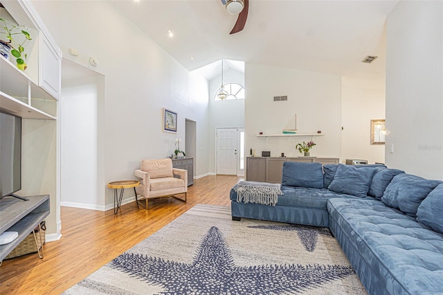 living room featuring hardwood / wood-style floors, high vaulted ceiling, and ceiling fan