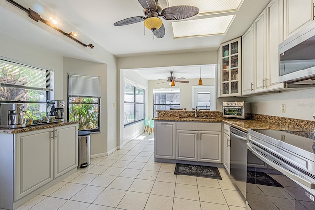 kitchen with sink, stainless steel appliances, kitchen peninsula, and white cabinets