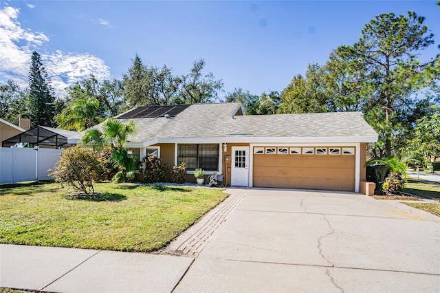 ranch-style home with a garage, a front lawn, and solar panels